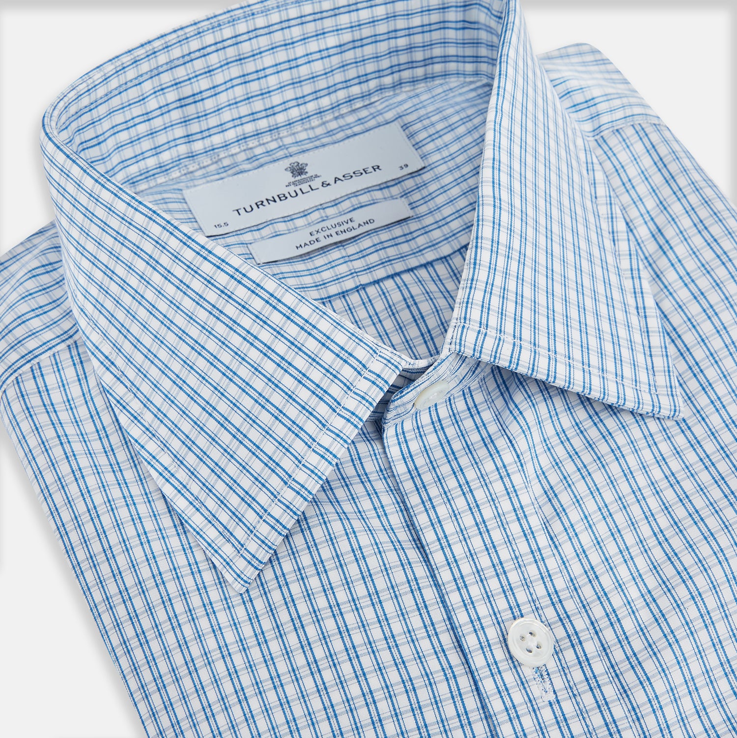 View 2 of product The Sky Blue Micro Graph Check Mayfair Shirt by Turnbull & Asser features a classic T&A collar, button-down front, and buttoned cuffs, shown laid flat on a white background.