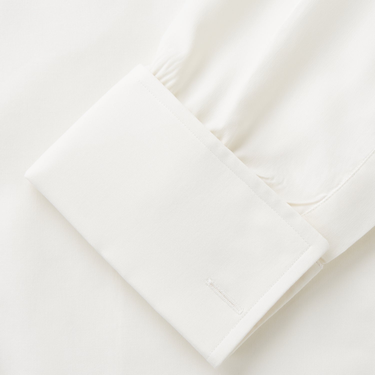 View 4 of product The Cream Silk Whitby Shirt by Turnbull & Asser features a pointed collar, buttoned front and cuffs, and long sleeves, shown in Whitby Fit and laid flat on a white background.