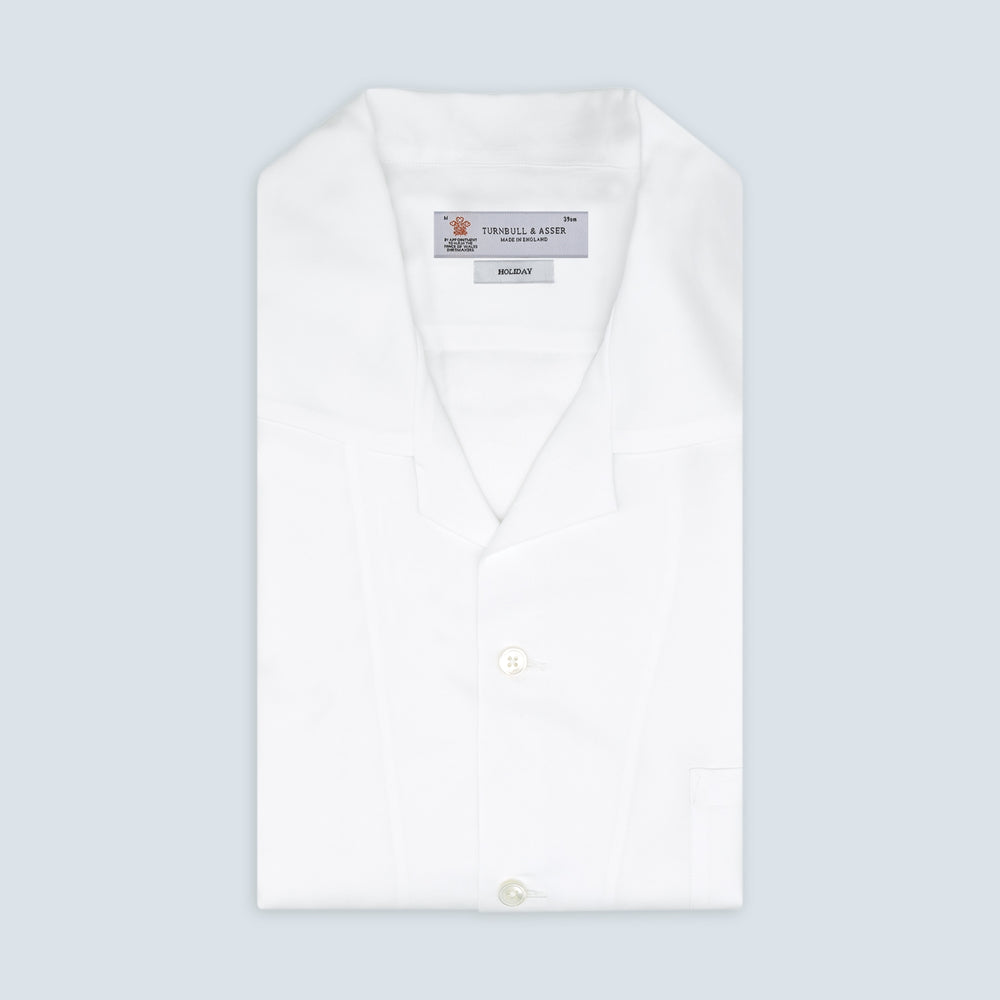 The White Lyocell Hampton Open Collar Shirt by Turnbull & Asser is neatly folded with visible label, notched collar, and buttons, displayed against a light grey background.