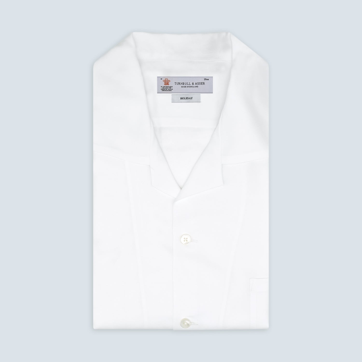 View 1 of product The White Lyocell Hampton Open Collar Shirt by Turnbull & Asser is neatly folded with visible label, notched collar, and buttons, displayed against a light grey background.