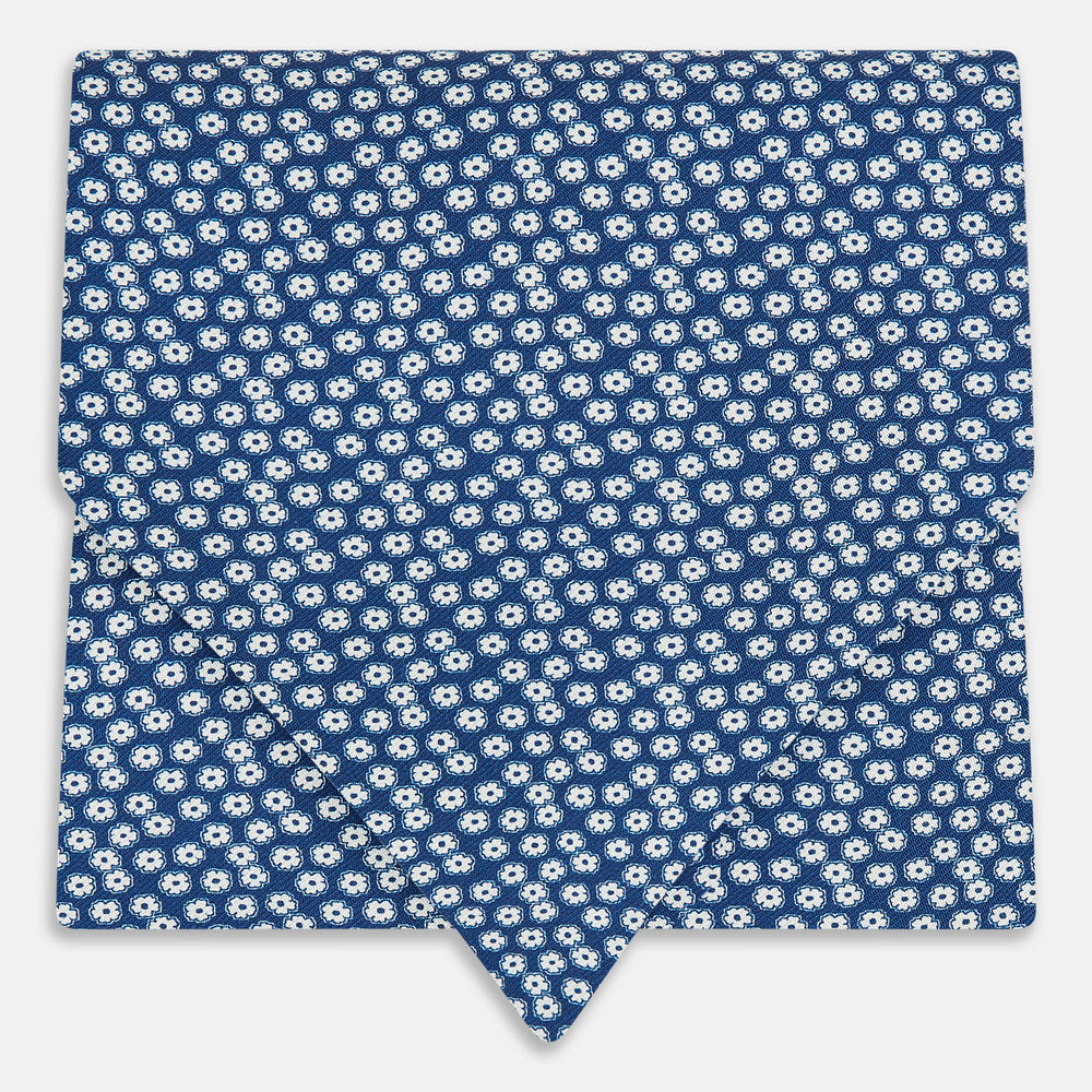 The Azzurro Flower Patterned Silk Cravat by Turnbull & Asser features a classic blue design with small white flowers—a refined British-inspired accessory.