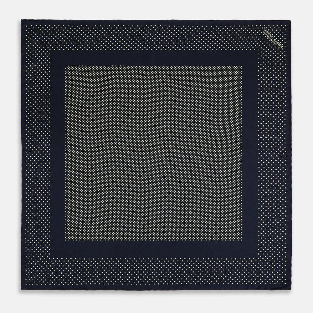 The Turnbull & Asser Navy and Gold Silk Pocket Square is handmade, featuring small gold polka dots on navy with a solid border, displayed neatly folded with one corner turned up.