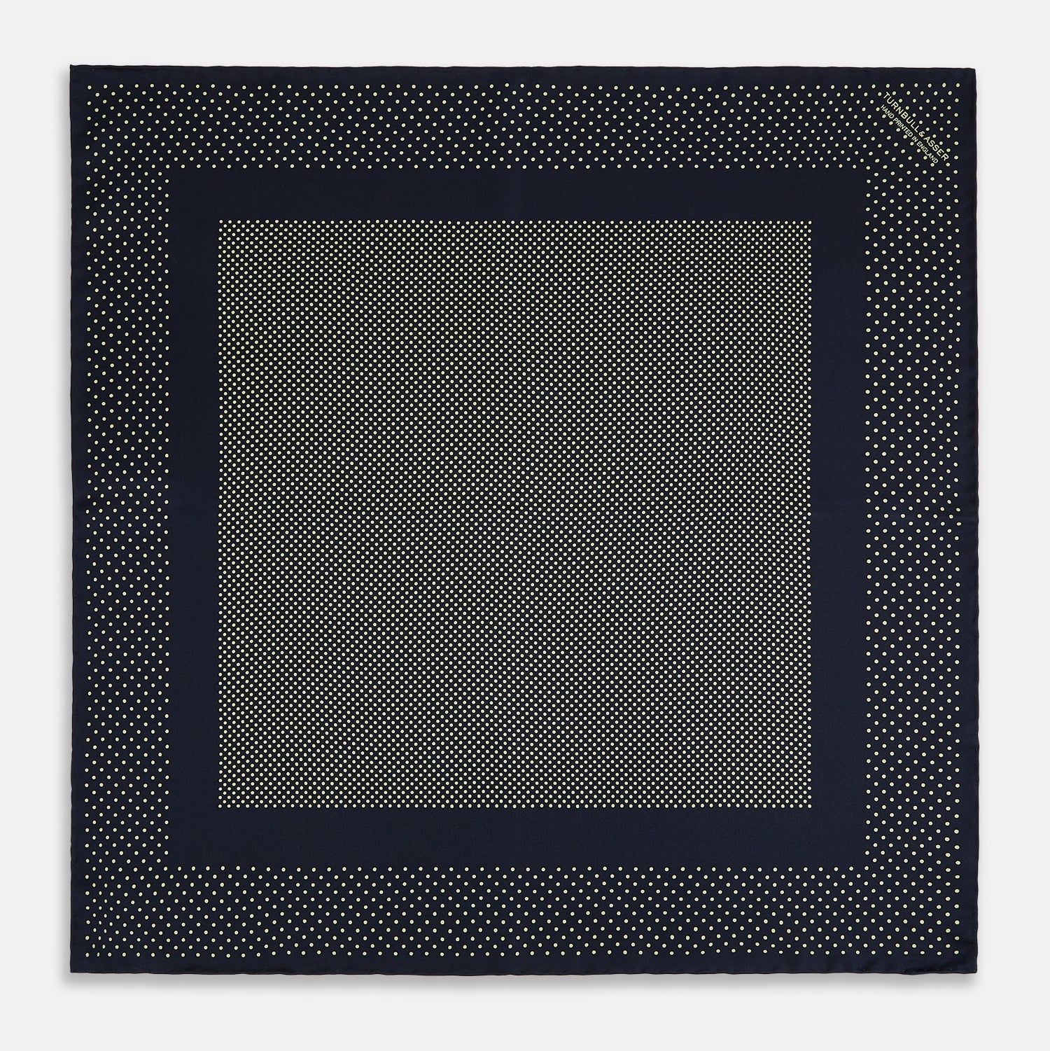 View 4 of product The Turnbull & Asser Navy and Gold Silk Pocket Square is handmade, featuring small gold polka dots on navy with a solid border, displayed neatly folded with one corner turned up.