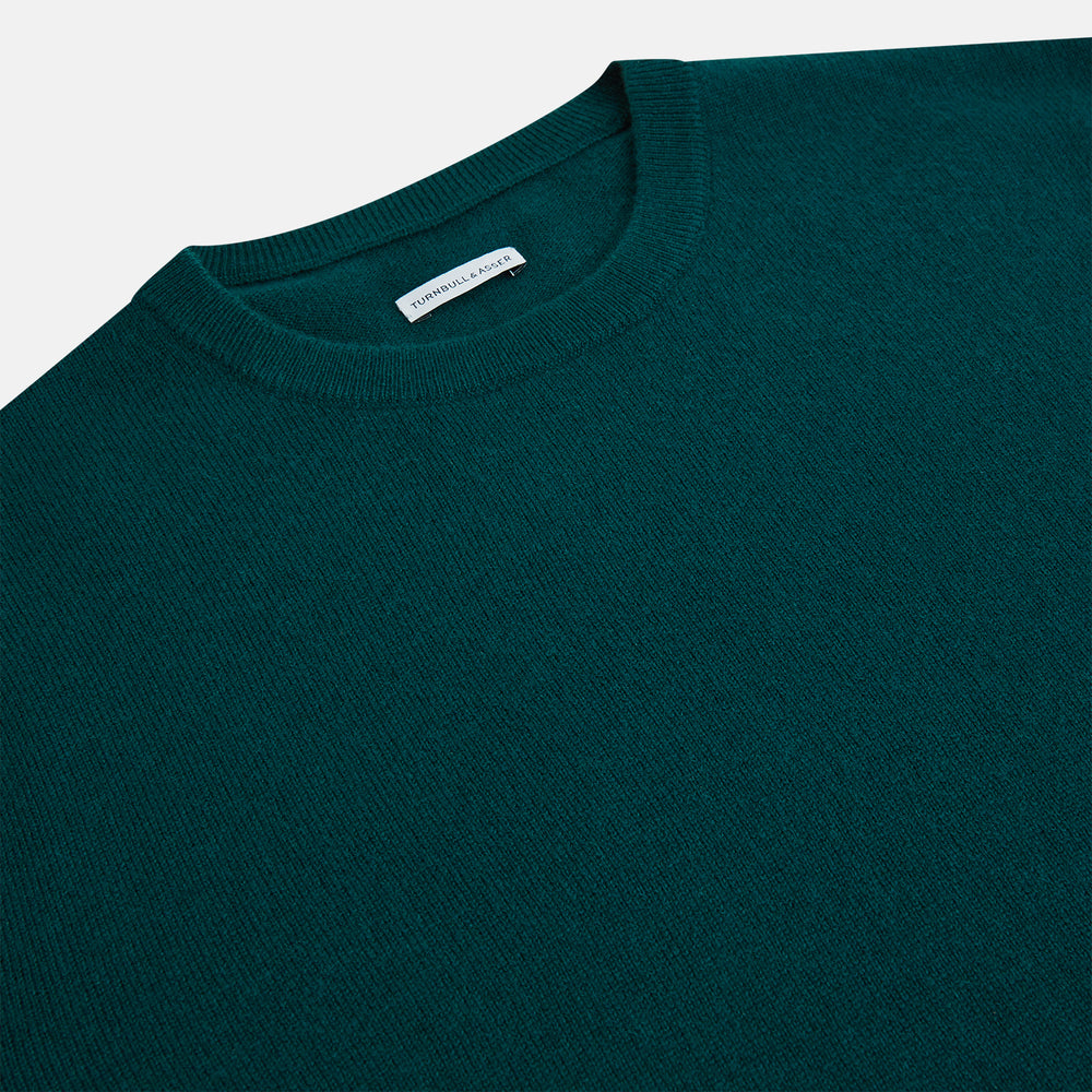 The Turnbull & Asser Moss Green Cashmere Round Neck Jumper, shown on a plain white background, is men's knitwear with long sleeves and a classic design featuring ribbed cuffs, neckline, and hem for timeless style.