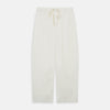 View 6 of product The Women's Harriet Cream Silk Pyjama Set by Turnbull & Asser features a white sand-washed silk button-up top with black piping and chest pocket, plus matching drawstring pants, all shown against a white background.