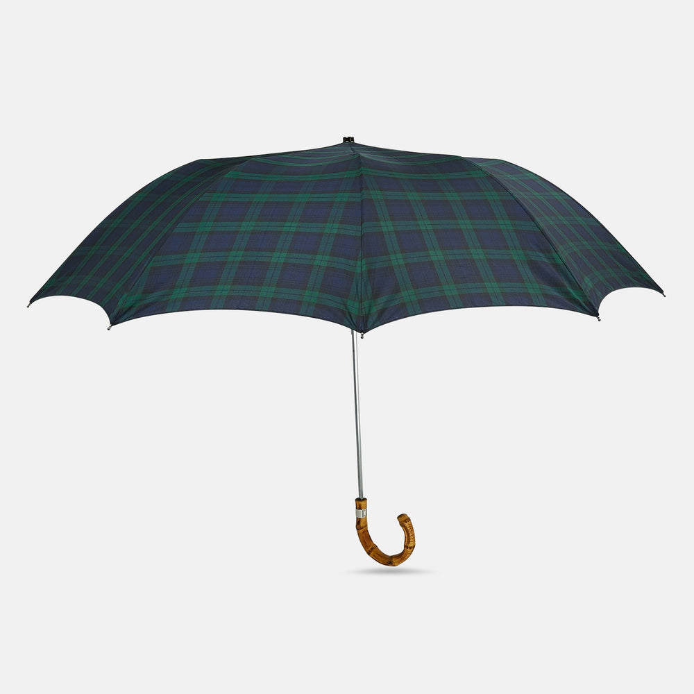 The Turnbull & Asser Black Watch Tartan Telescopic Umbrella features a classic dark green and blue plaid design with a whangee crook handle, highlighting the brand’s renowned craftsmanship against a plain white background.