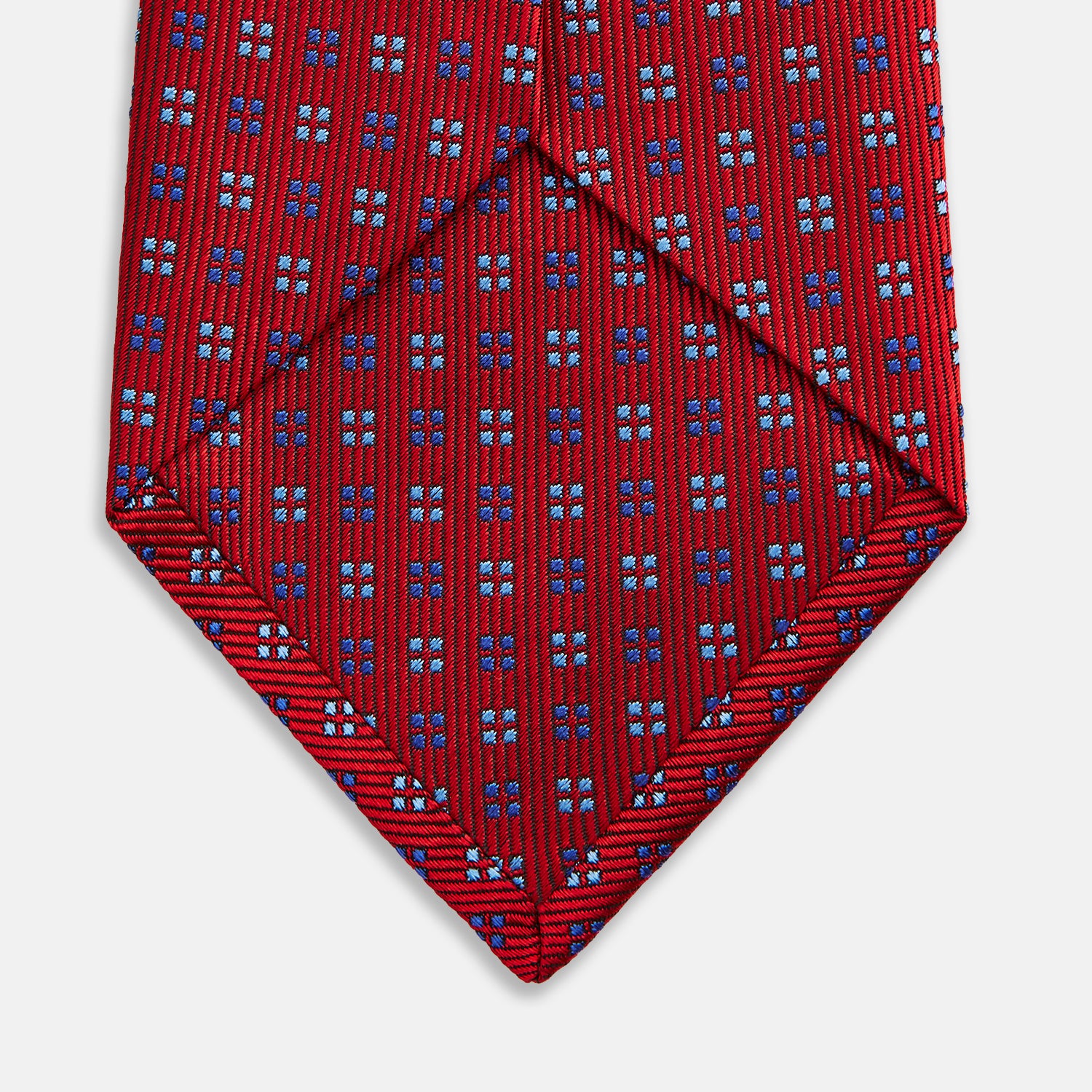 View 4 of product The Turnbull & Asser MINI SQUARE SPOT TULIP RED BLUE TIE features a vivid red base with blue and white geometric spots, making it a stylish addition to any refined ensemble.