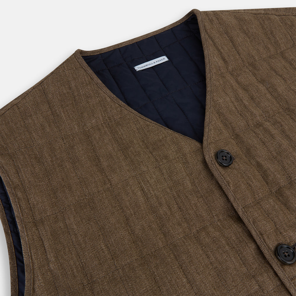 The Turnbull & Asser Pine Cone Quilted Linen Herringbone Waistcoat features a brown, sleeveless design with dark buttons, two angled side pockets, and a chest pocket, shown on a plain white background.