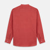 View 7 of product The Turnbull & Asser Plain Red Linen Weekend Fit Shirt with Stand Collar features long sleeves, a button-up front, and two buttoned-flap chest pockets. It is shown neatly laid flat on a plain light background.