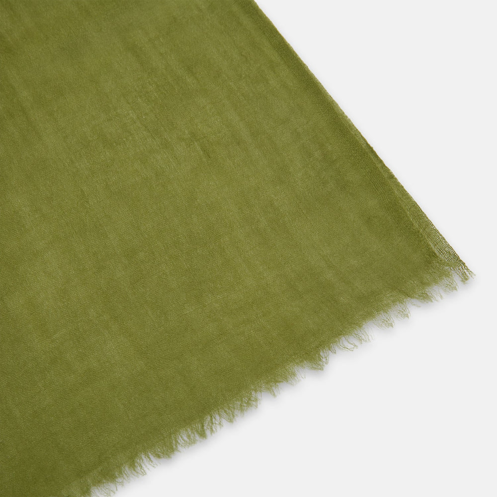 The Moss Green Cashmere Scarf by Turnbull & Asser features a lightweight, slightly sheer texture with subtle unfinished fringe ends. Loosely folded and draping elegantly, it’s a true luxury accessory set against a plain white background.