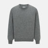 View 1 of product The Turnbull & Asser Grey Melange Cashmere Round Neck Jumper for men features a classic crewneck design with ribbed cuffs, hem, and neckline, displayed against a white background.