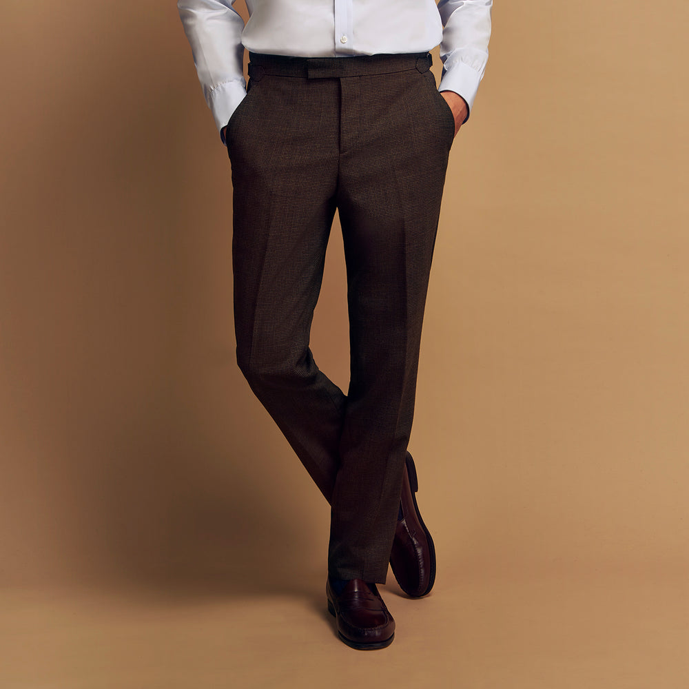 The Brown Puppytooth Wool Jonathan Trousers by Turnbull & Asser are straight-leg tailored trousers with belt loops, side pockets, and a front crease, shown on a white background.