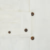View 4 of product The Vanilla Linen Holland Shacket by Turnbull & Asser, a white Irish linen button-up with a collar, brown buttons, and four pockets, is laid flat on a white background—perfect as lightweight outerwear.