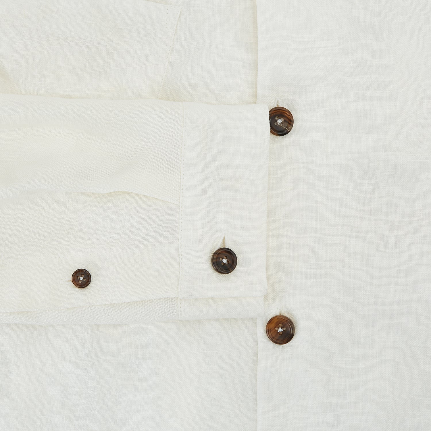 View 4 of product The Vanilla Linen Holland Shacket by Turnbull & Asser, a white Irish linen button-up with a collar, brown buttons, and four pockets, is laid flat on a white background—perfect as lightweight outerwear.
