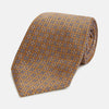 View 1 of product The Turnbull & Asser Tan and Blue Multi Dot Silk Tie is rolled up, showcasing a refined dotted pattern on silk—an elegant accessory ideal for elevating modern office attire.