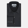 View 5 of product The Charcoal Windsor Shirt by Turnbull & Asser is a black, long-sleeve button-up with a pointed Windsor collar, buttoned cuffs, and a straight hem, shown flat on a white background.