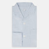 View 5 of product The Turnbull & Asser Blue Graph Check Pyjama Shirt features long sleeves, a collar, and a small check pattern in light blue—ideal as elegant loungewear.