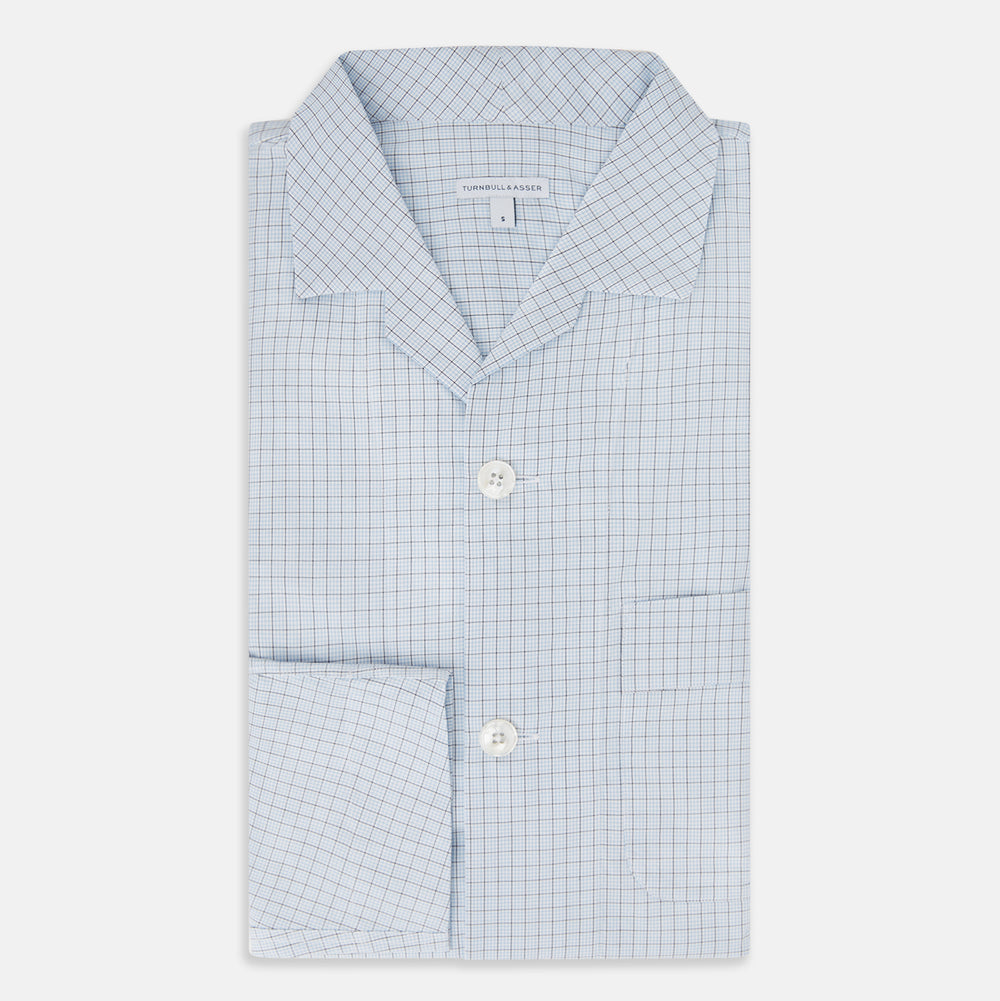 The Turnbull & Asser Blue Graph Check Pyjama Shirt features long sleeves, a collar, and a small check pattern in light blue—ideal as elegant loungewear.