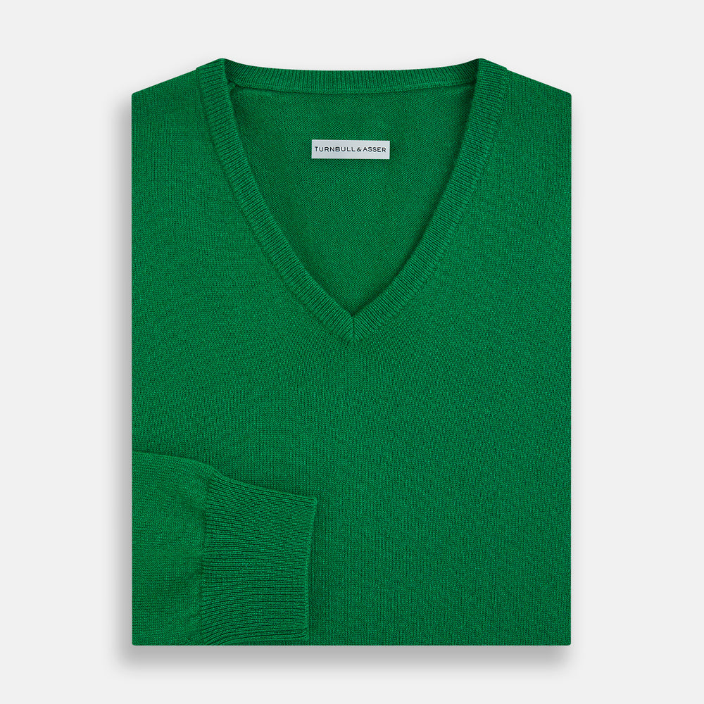 The Turnbull & Asser Grass Green Cashmere V-neck Jumper, with long sleeves, is displayed against a white background, highlighting its classic knitwear style.