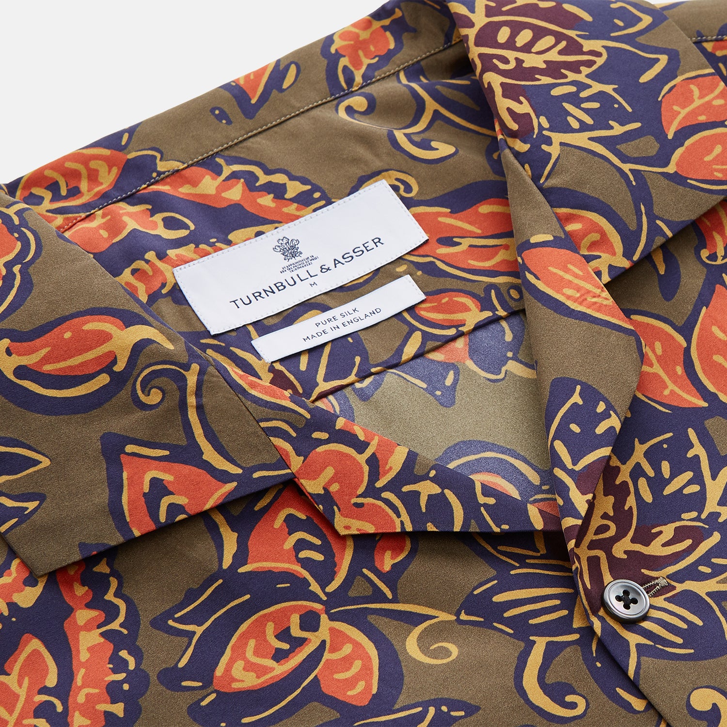 View 4 of product The Turnbull & Asser Khaki Green Floral Silk Holiday Fit Winnington Shirt features a bold floral print with orange, yellow, and purple on an olive background, plus a spread collar and chest pocket for versatile style.