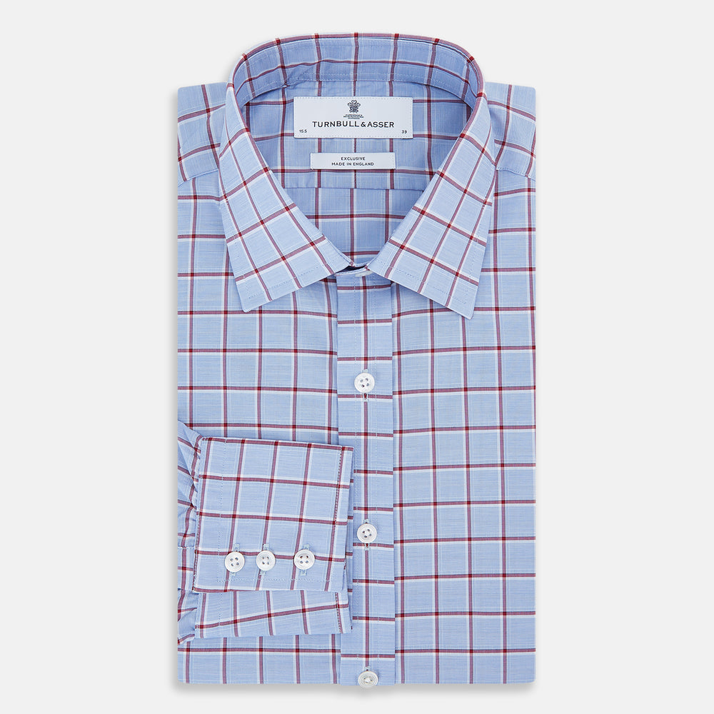 The Turnbull & Asser Blue and Burgundy Windowpane Mayfair Shirt features long sleeves, a light blue base with burgundy windowpane checks, a classic collar, and white buttons.