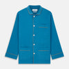 View 6 of product The Turnbull & Asser Blue Silk Hyde Pyjama Set features a modern fit with a long-sleeve button-up top, three pockets, white trim, and elastic-waist pants, all shown on a white background.
