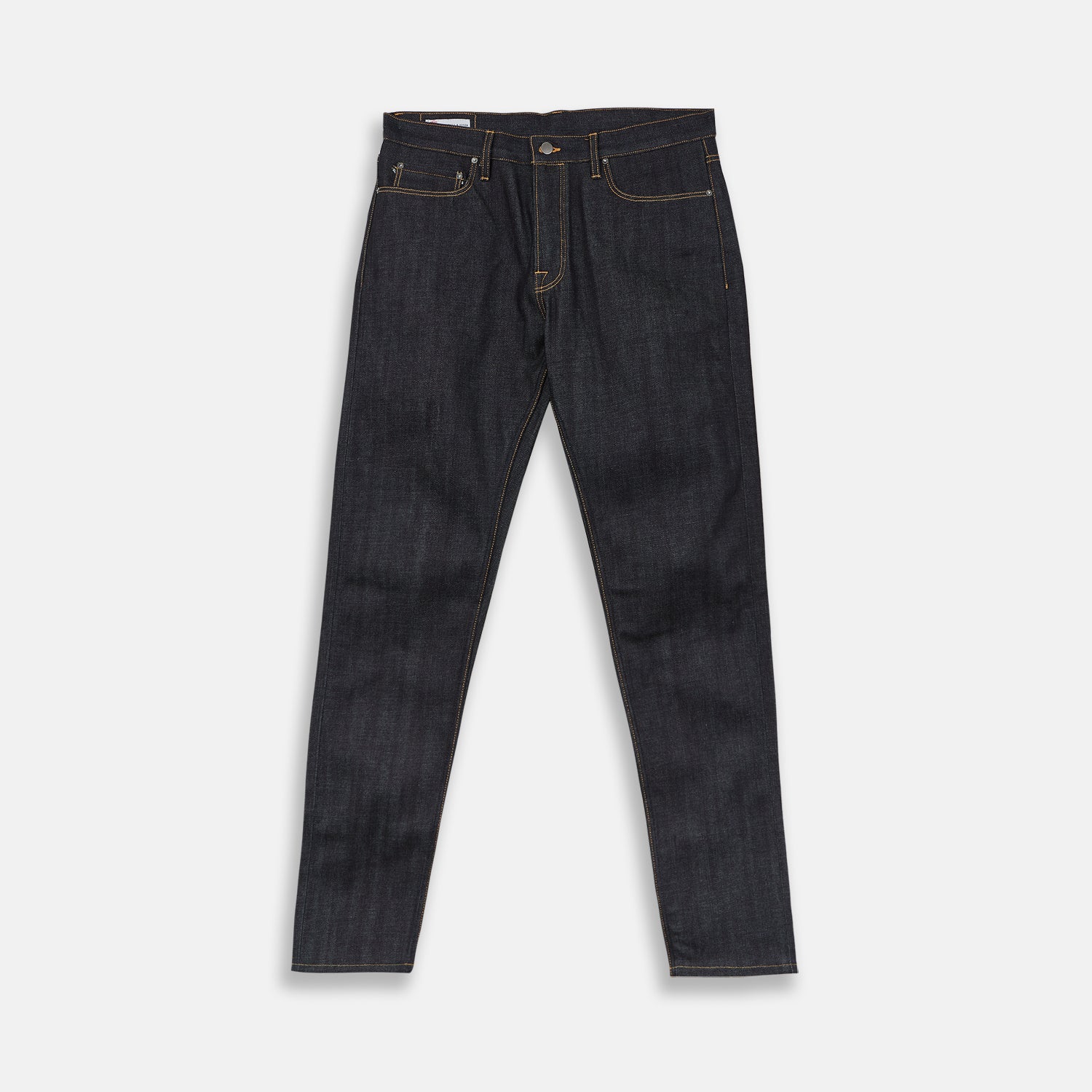 View 4 of product A pair of Turnbull & Asser Indigo Japanese Selvedge Denim Jeans in dark blue with rolled-up cuffs, yellow stitching, five pockets, and a button fly, laid flat on a white background.