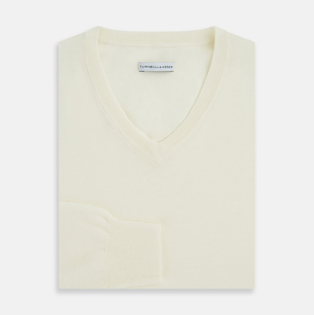 The Turnbull & Asser Cream Fine Merino V-Neck Jumper features long sleeves and classic styling, displayed against a white background.