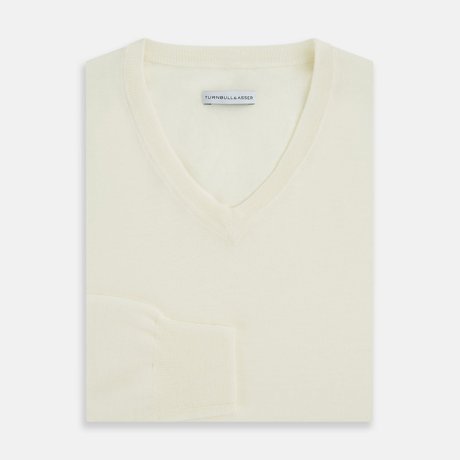 View 10 of product The Turnbull & Asser Cream Fine Merino V-Neck Jumper features long sleeves and classic styling, displayed against a white background.