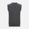 View 3 of product The Turnbull & Asser Charcoal Grey Cashmere Sleeveless Cardigan is a men's knit V-neck vest with ribbed collar, hem, and two front pockets, shown in dark grey melange against a white background.