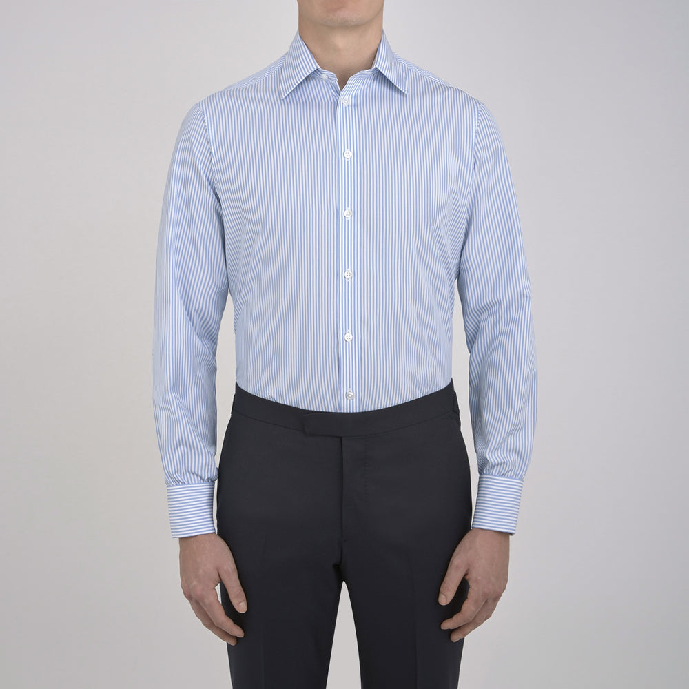 The Turnbull & Asser Light Blue Bengal Stripe Shirt features a classic T&A collar, double cuffs, and white buttons. Made from cotton with blue and white stripes, it's neatly displayed against a plain white background.