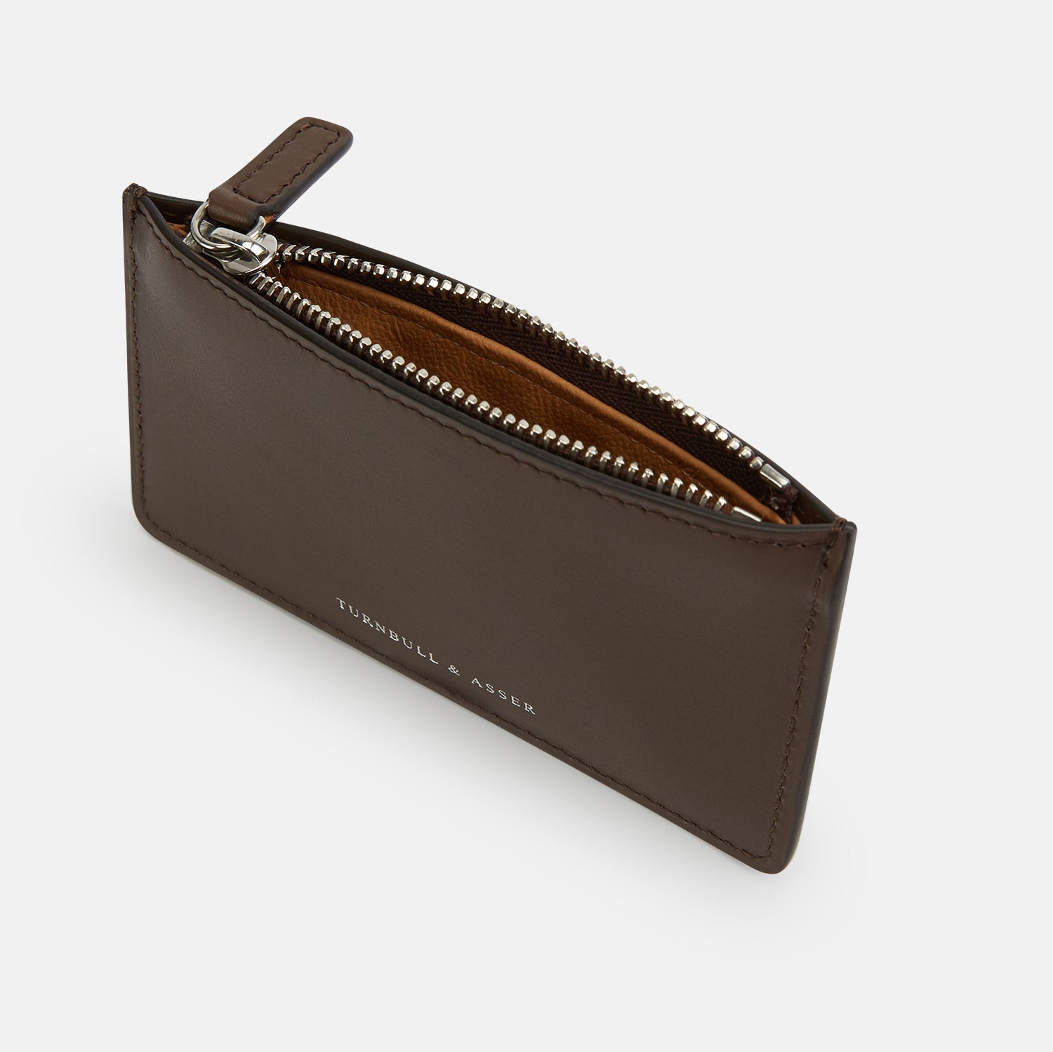 View 2 of product The Dark Chocolate Leather Zip Wallet by Turnbull & Asser, crafted from full-grain Italian leather, features a white brand logo on the front and is displayed against a plain white background.