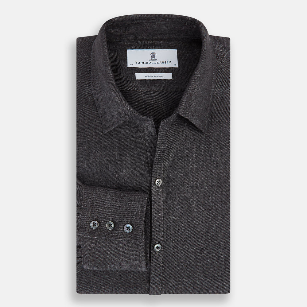The Ash Linen Windsor Shirt by Turnbull & Asser is a long-sleeve, button-up black shirt with a Windsor collar and cuffs, reflecting British craftsmanship, shown on a plain white background.