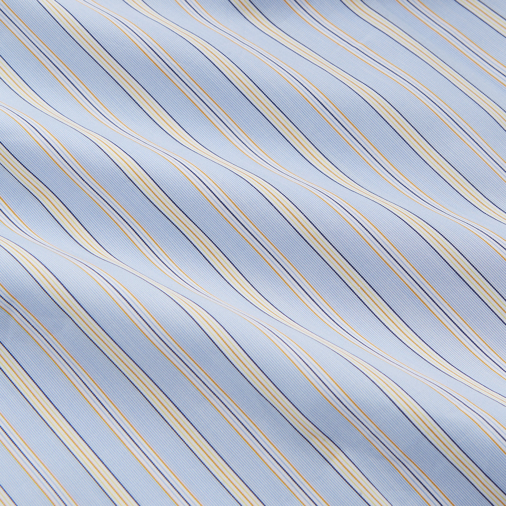The Turnbull & Asser Blue and Yellow Stripe Poplin Cotton Nightshirt features light blue and yellow vertical stripes, long sleeves, a classic collar, single chest pocket, rounded hem, and is displayed flat on a white background.