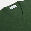 View 2 of product The Turnbull & Asser Green V-Neck Cashmere Jumper, made from soft Scottish cashmere, features long sleeves with ribbed cuffs and a ribbed hem. It is shown laid flat on a white background.