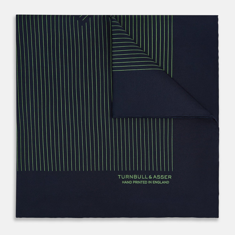The Navy and Fern Green Stripe Silk Pocket Square by Turnbull & Asser features green vertical and diagonal stripes, hand-rolled edges, and "TURNBULL & ASSER HAND PRINTED IN ENGLAND" printed in one corner.