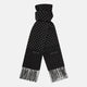 The Turnbull & Asser Black and White Spotted Silk Scarf with Fringes features a classic polka dot design, silver fringe edges, and the brand name printed near each end.