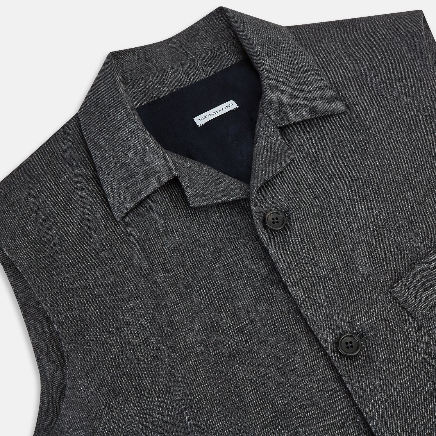 View 2 of product The Turnbull & Asser Ash Collared Linen Waistcoat is a sleeveless dark gray piece with a button-down front, two zippered side pockets, and a small chest pocket, shown against a plain white background.