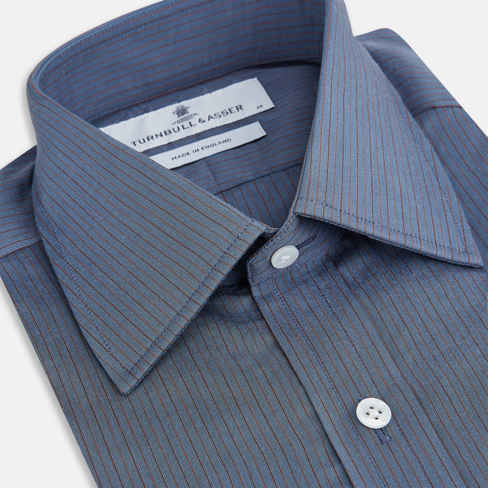 A neatly folded men's Mid Blue Red Stripe Regular Fit Mayfair Shirt by Turnbull & Asser, featuring long sleeves, classic collar, white buttons, and subtle red stripes—a hallmark of the brand’s renowned luxury.