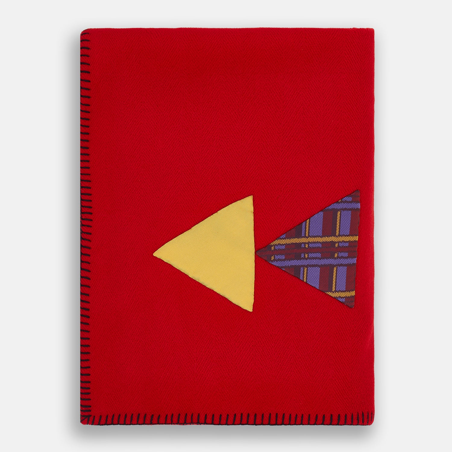 View 1 of product The Turnbull & Asser Red Applique Hand Stitched Lambswool Blanket features black-stitched edges and handsewn tie silk patches, including a yellow triangle and plaid triangle arranged to form a stylized fish.
