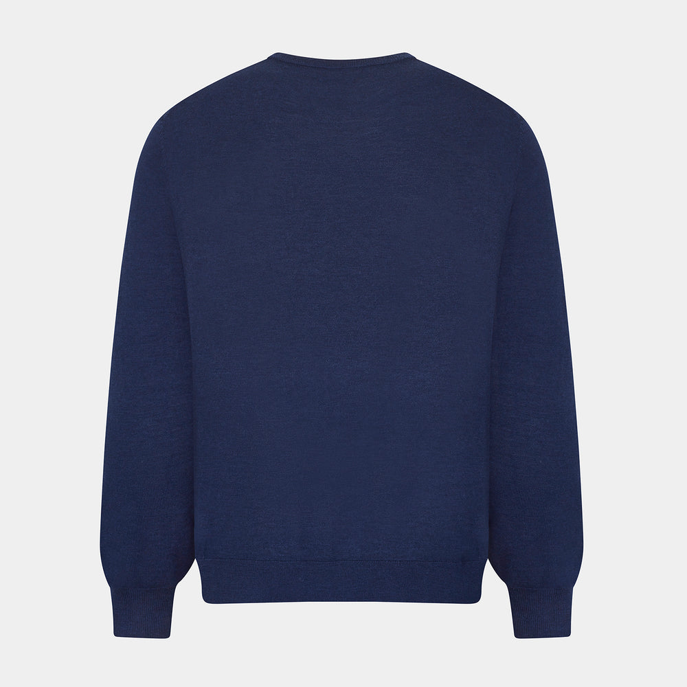 The Turnbull & Asser Navy Merino Round Neck Jumper is shown against a light gray background, featuring a classic long-sleeve design with ribbed cuffs, hem, and neckline for timeless style.