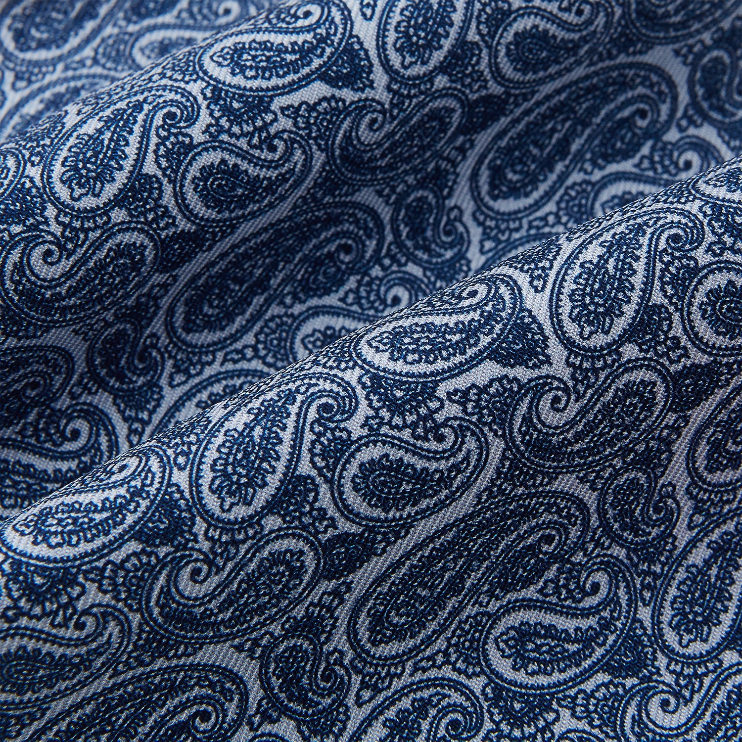 View 4 of product The Pale Blue Paisley Silk Cravat by Turnbull & Asser showcases intricate, swirling blue and white paisley designs on a light background, echoing the elegance of British style accessories.