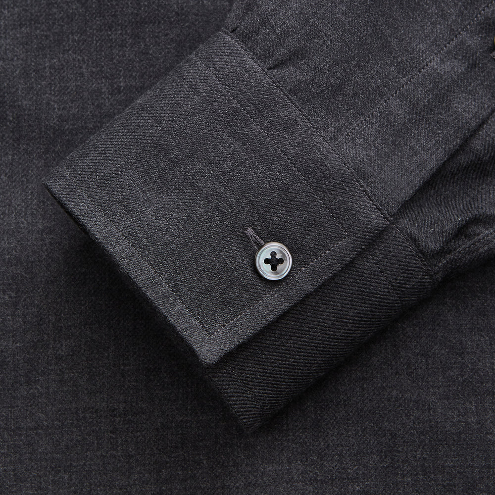 The Turnbull & Asser Charcoal Cotton Blend Weekend Fit Blake Shirt is a long-sleeve, stand-collar shirt with white buttons. Its minimalist design, with no pockets or patterns, makes it perfect for casual wear. Displayed flat on a white background.