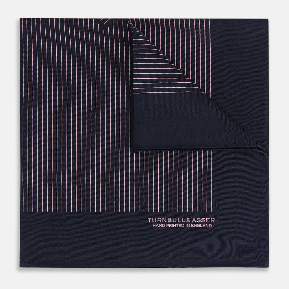 The Navy and Pink Stripe Silk Pocket Square by Turnbull & Asser features thin pink stripes, a geometric border, hand-rolled edges, and "TURNBULL & ASSER HAND PRINTED IN ENGLAND" printed in white.