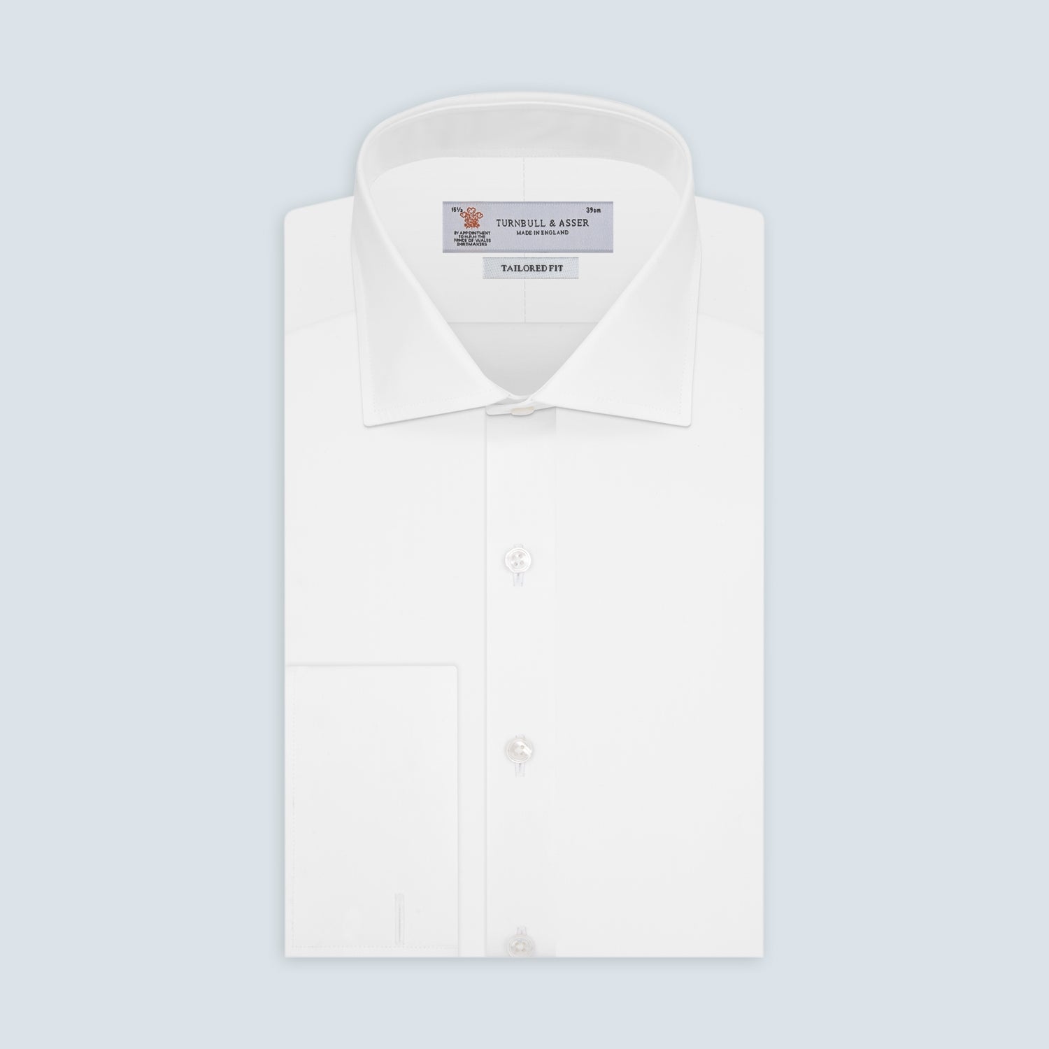 View 1 of product The Turnbull & Asser Tailored Fit Two-Fold 120 White Cotton Shirt features a Kent collar, double cuffs, and button-down front, displayed neatly folded against a light blue background.