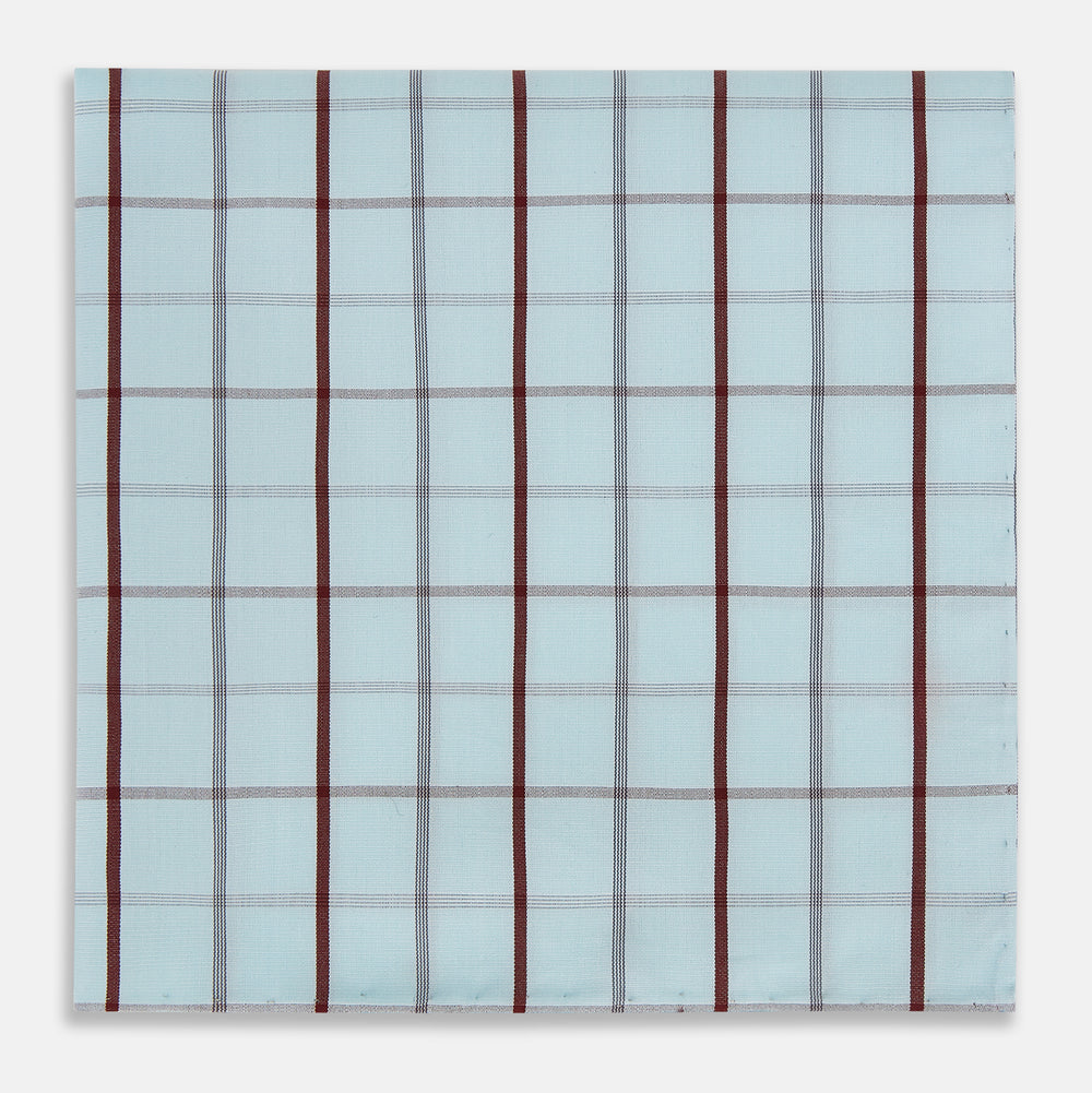The Turnbull & Asser Burgundy Combination Check Hand-Rolled Handkerchief, featuring a light blue plaid with thin gray lines and bold dark red stripes, is displayed flat against a white background.