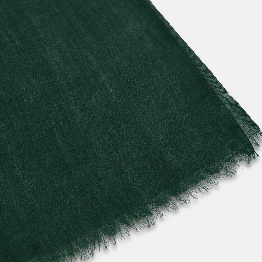 The Turnbull & Asser Forest Green Cashmere Scarf features a hand-dyed finish, soft texture, and lightly frayed edges, artfully tied in a loose knot and displayed on a white background—a true luxury accessory.