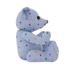 View 1 of product The Turnbuline Cotton Spot Teddy Bear by Turnbull & Asser is a blue gingham bear with colorful polka dots, black button eyes, a black nose, and a white leg label, shown sitting upright in profile facing left.