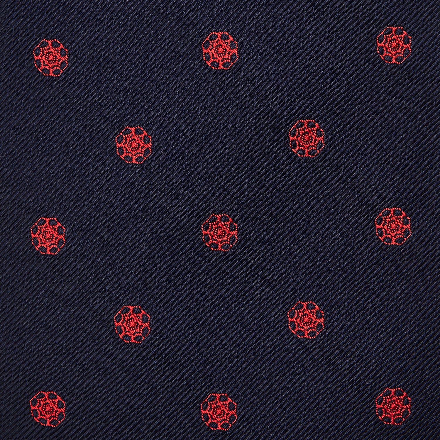 View 3 of product The EMBLEM SPOT NAVY TULIP TIE by Turnbull & Asser features a navy base with red circle motifs, neatly rolled on a white background—an essential accessory for refined style.