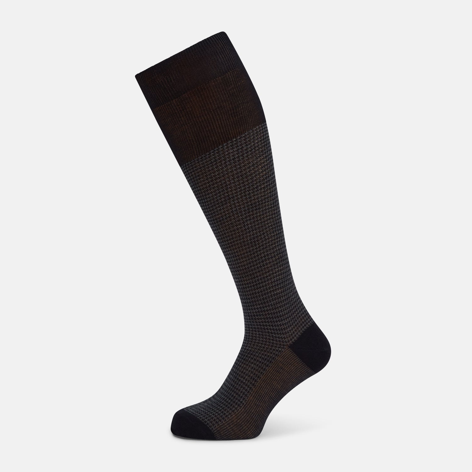 View 1 of product The Turnbull & Asser Charcoal Melange Houndstooth Long Sock is knee-high, with a subtle dark houndstooth pattern and solid black toe, heel, and cuff, shown on a white background.